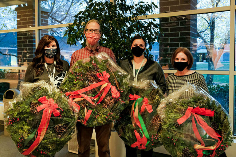 staff holding wreaths