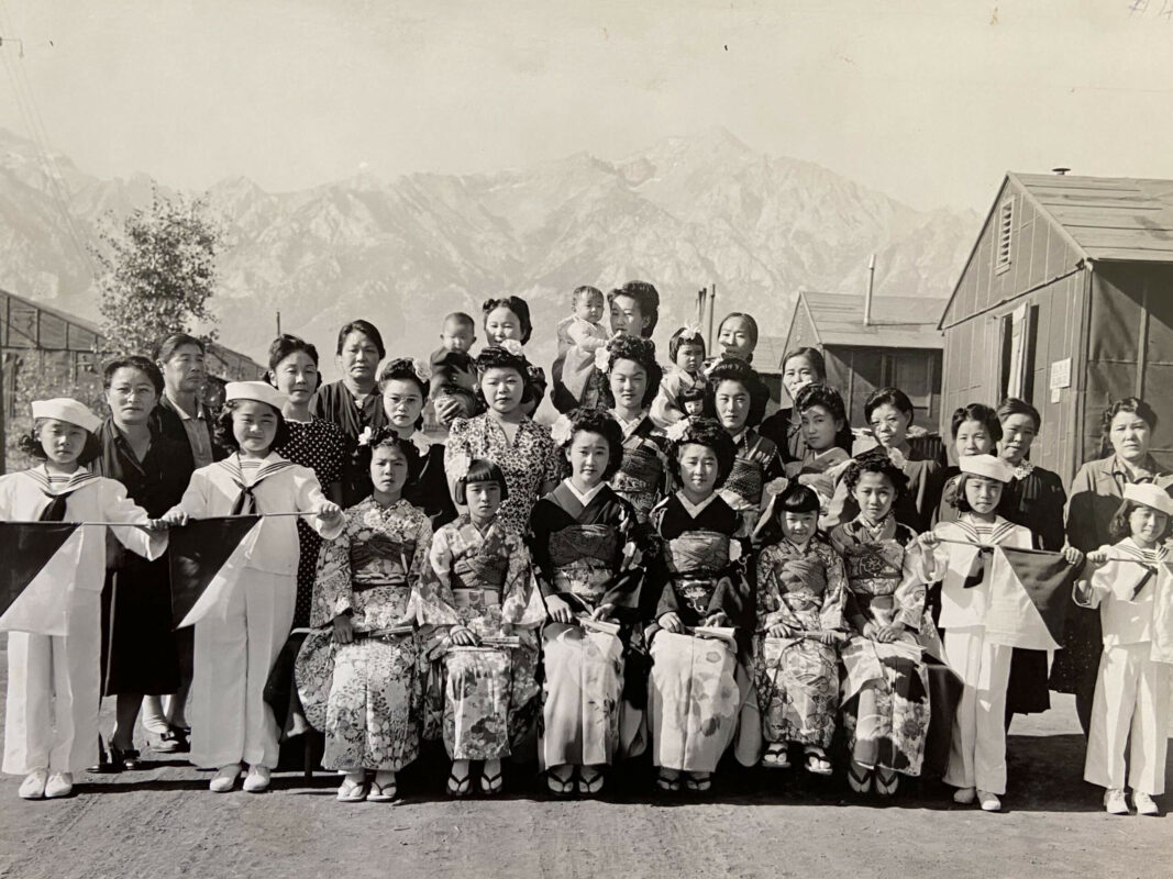 Bachi is in the very front row on the very left in the sailor outfit, holding a flag. This was taken before a dance performance in camp.